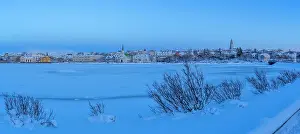 Tjornin Prints: View of the city skyline of Reykjavik from Tjornin lake at sunset in winter