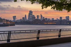 View of The City skyline at sunset from the Thames Path, London, England, United Kingdom