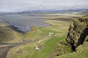 View down to the coast at Dyrholaey showing isolated farms and distant mountains