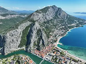 Popular Prints: View of the coastline and hills in Omis Croatia with clear skies and blue waters in the background during the daytime