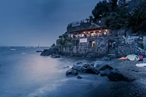 Outdoor Seating Prints: View of coastline restaurant near Aragonese Castle at dusk