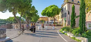 Pedestrians Prints: View of colourful buildings, cafe and cypress trees in Borgo San Giuliano