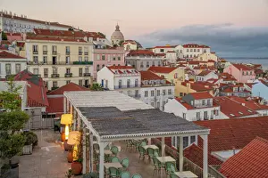 Terrace Prints: View of colourful buildings and red rooftops at sunset in the Alfama District