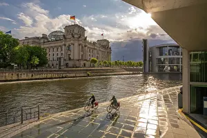 Reichstag Prints: View of cyclists and River Spree and the Reichstag (German Parliament building)