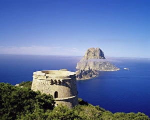 View of defence tower and the rocky island of Es Vedra