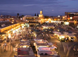 Market Place Prints: View over Djemaa el Fna at dusk with foodstalls and crowds of people, Marrakech