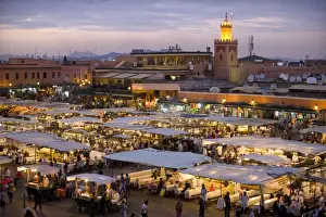 Market Place Prints: View over Djemaa el Fna at dusk with foodstalls that are set-up daily to serve tourists