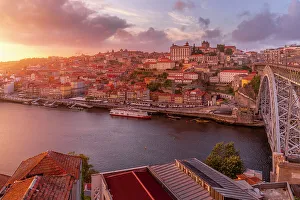 Connections Gallery: View of the Dom Luis I bridge over Douro River aligned with colourful buildings at sunset