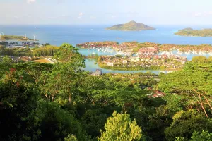 Tropics Prints: View of Eden Island from a high point in Seychelles with green trees and blue water in the background