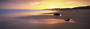 Day Break Prints: View along Embleton Bay at sunrise, with silhouette of Dunstanburgh Castle in the distance