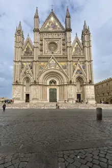 View of the facade of the Gothic cathedral with golden mosaics and bronze doors, Orvieto