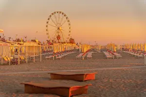 Ferris Wheel Prints: View of ferris wheel and sunshades on the Lido on Rimini Beach at sunrise