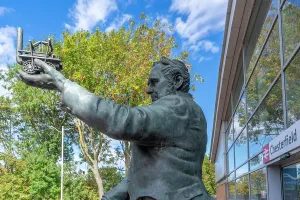 George Prints: View of George Stephenson Statue holding a model train at Chesterfield Station in England showcasing historical