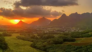 View of golden sunset behind Long Mountain and patchwork of green fields, Mauritius, Indian Ocean, Africa
