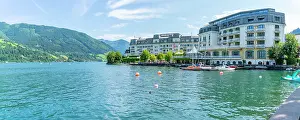 Austria Prints: View of the Grand Hotel on Lake Zell from Zell am See and mountainous backdrop on a sunny day
