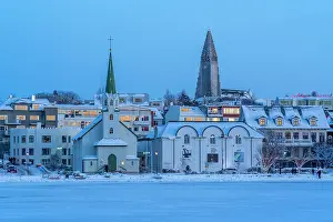 Tjornin Prints: View of the Hallgrimskirkja Church and city skyline of Reykjavik from Tjornin lake at sunset in winter