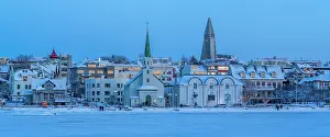 Stillness Prints: View of the Hallgrimskirkja Church and city skyline of Reykjavik from Tjornin lake at sunset in winter