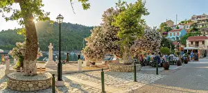 Eateries Prints: View of harbourside restaurant and colourful houses in Assos in golden hour