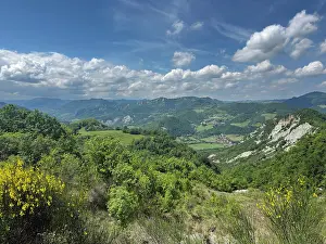 Ecosystems Prints: View of hills and valley in Monte Sole Historical Park showing green landscape and cloudy sky in Italy