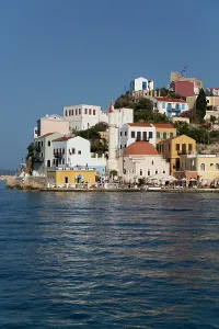 Dodecanese Prints: View of houses and harbor near a mosque in Megisti Bay with a fort on the Dodecanese Islands in Greece