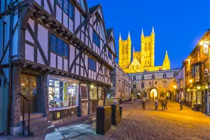 Cobbled Prints: View of illuminated Lincoln Cathedral viewed from Exchequer Gate with timbered architecture