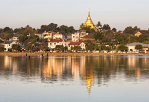 View of Kengtung (Kyaingtong) looking across Naung Tung Lake towards the town and gilded stupa of Wat Jong Kham bathed in evening light, Kengtung, Shan State, Myanmar (Burma), Asia