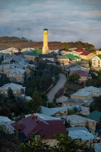 Settlement Prints: View of Kubachi town in Dagestan with houses and a tall tower surrounded by fog in the early morning