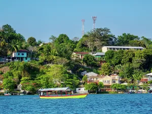 Miguel Prints: View over Lake Peten Itza with boat near San Miguel and buildings along the shore in Flores