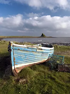 Lobster Pot Prints: View towards Lindisfarne Castle with old fishing coble and lobster pots in the foreground