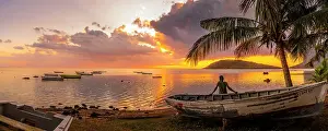 One Person Only Prints: View of local man sat on boat viewing Le Morne from Le Morne Brabant at sunset