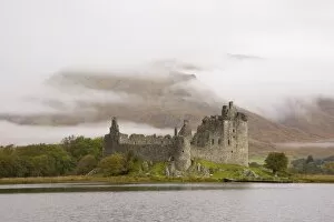 View across Loch Awe to the ruins of Kilchurn Castle, early morning mist on mountains