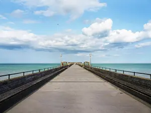 Benches Prints: View of the long pier extending into the sea with clouds in the sky at Deal