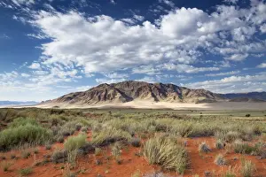 Namib Rand Prints: View across magnificent landscape of orange sand dunes and sandstones mountains at Wolwedans