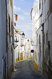 Paving Prints: View along the medieval cobbled street of Rua do Moeda in historic centre of Evora