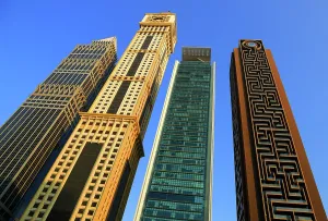 Tall Prints: View of modern buildings in Central Dubai showcasing unique architectural styles and designs during bright daylight