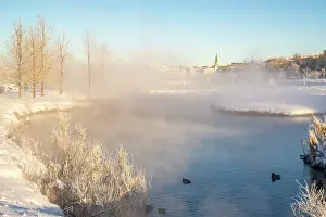 Lakeside Prints: View of morning mist in Tjornin park and Lutheran Free Church on a sunny day in winter