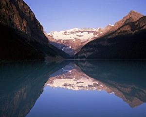View to Mount Victoria across the still waters of Lake Louise, at sunrise