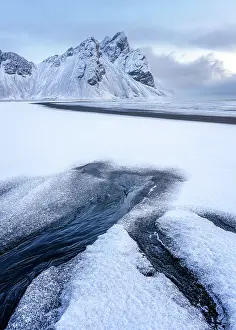Glacial Prints: View of the mountains of Vestrahorn from black volcanic sand beach after snowfall
