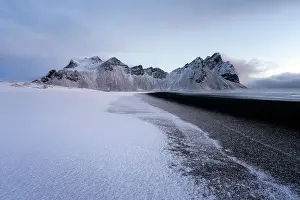 Frost Prints: View of the mountains of Vestrahorn from black volcanic sand beach after snowfall