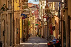 Sassari Prints: View of narrow street lined with rustic buildings in Sassari