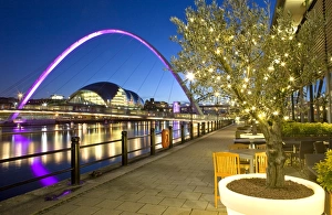 View along Newcastle Quayside at night showing the River Tyne, the floodlit Gateshead Millennium Bridge and the Sage Gateshead, Newcastle-upon-Tyne, Tyne and Wear, England, United
