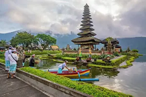 Bali Prints: View of offerings being made at Ulun Danu Beratan temple on Lake Bratan at sunrise