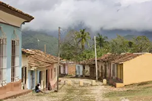 View along old street against backdrop of cloud-covered hills after heavy rainfall