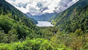 Fresh Prints: View from the overlook of Ritsa Lake showing mountains and lush forests in a natural landscape with clouds above