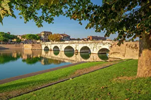 View of Ponte di Tiberio reflecting in Rimini Canal, Rimini, Emilia-Romagna, Italy, Europe