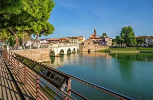 View of Ponte di Tiberio reflecting in Rimini Canal from Borgo San Giuliano, Rimini, Emilia-Romagna, Italy, Europe