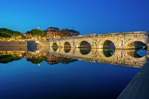 Rimini Prints: View of Ponte di Tiberio reflecting in Rimini Canal in Borgo San Giuliano district at dusk