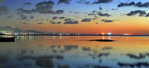 Mauritius Prints: View of Port Louis at twilight with reflections in the water and city lights in the background