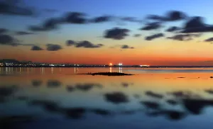 Maritime Prints: View of Port Louis at twilight with reflections on water and clouds above in Mauritius