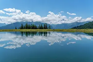 Mirror Prints: View of reflection of mountains and clouds in Plettsaukopf Reservoir on a sunny day